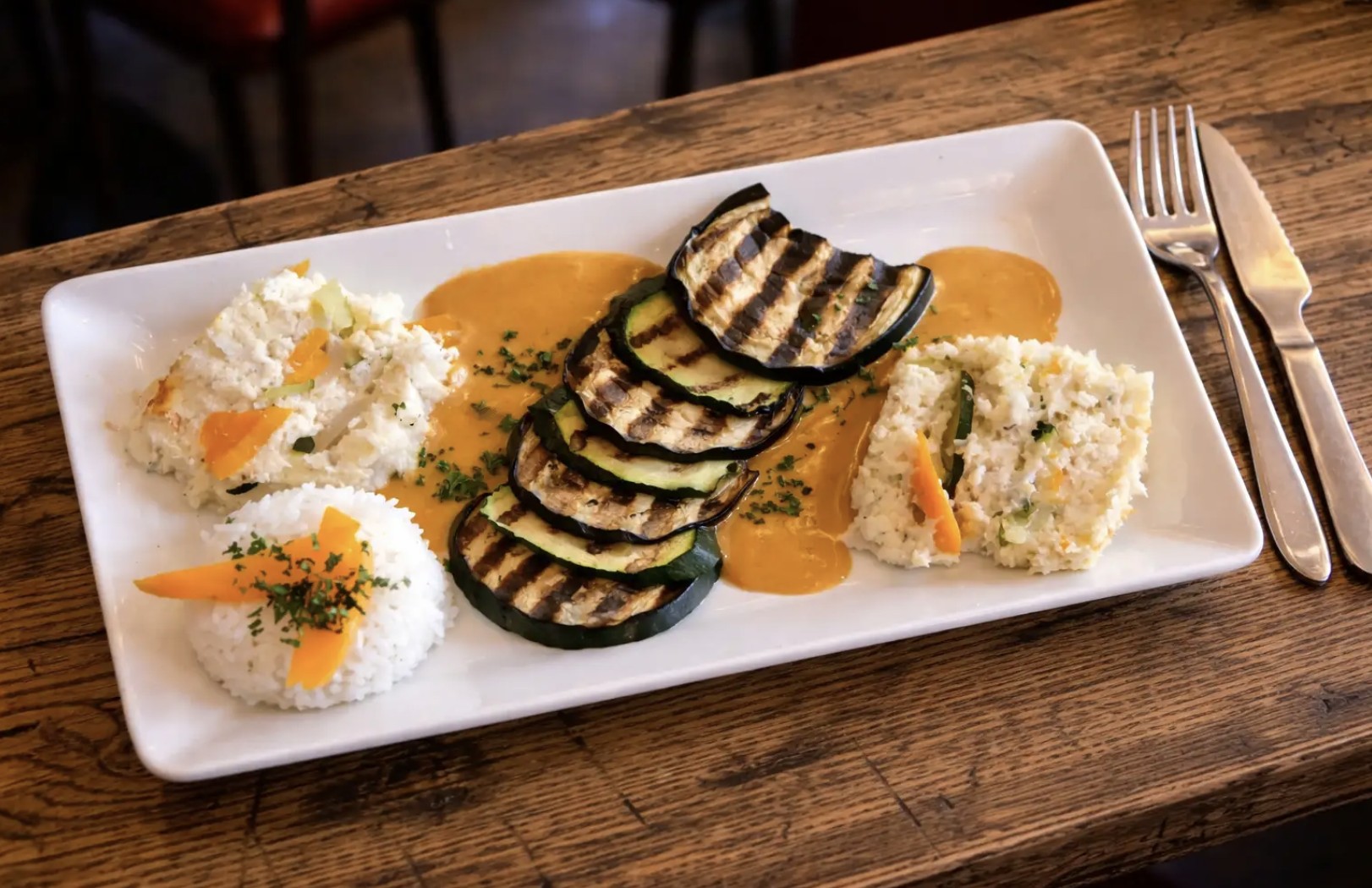 Assiette gastronomique avec aubergines grillées, purée et sauce dorée