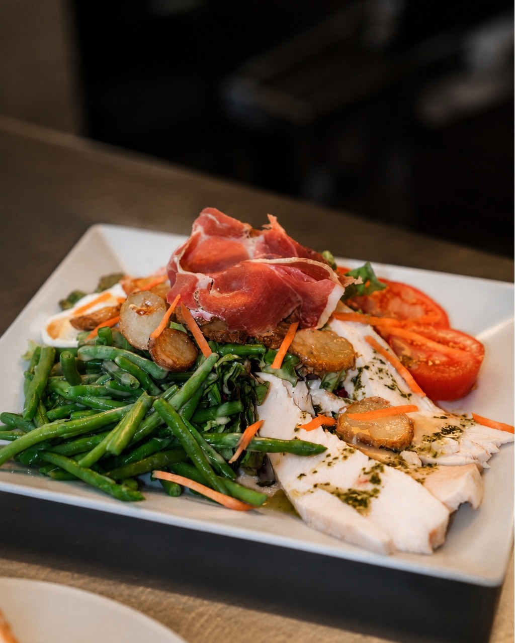 Assiette gastronomique avec jambon cru, poisson blanc et haricots verts