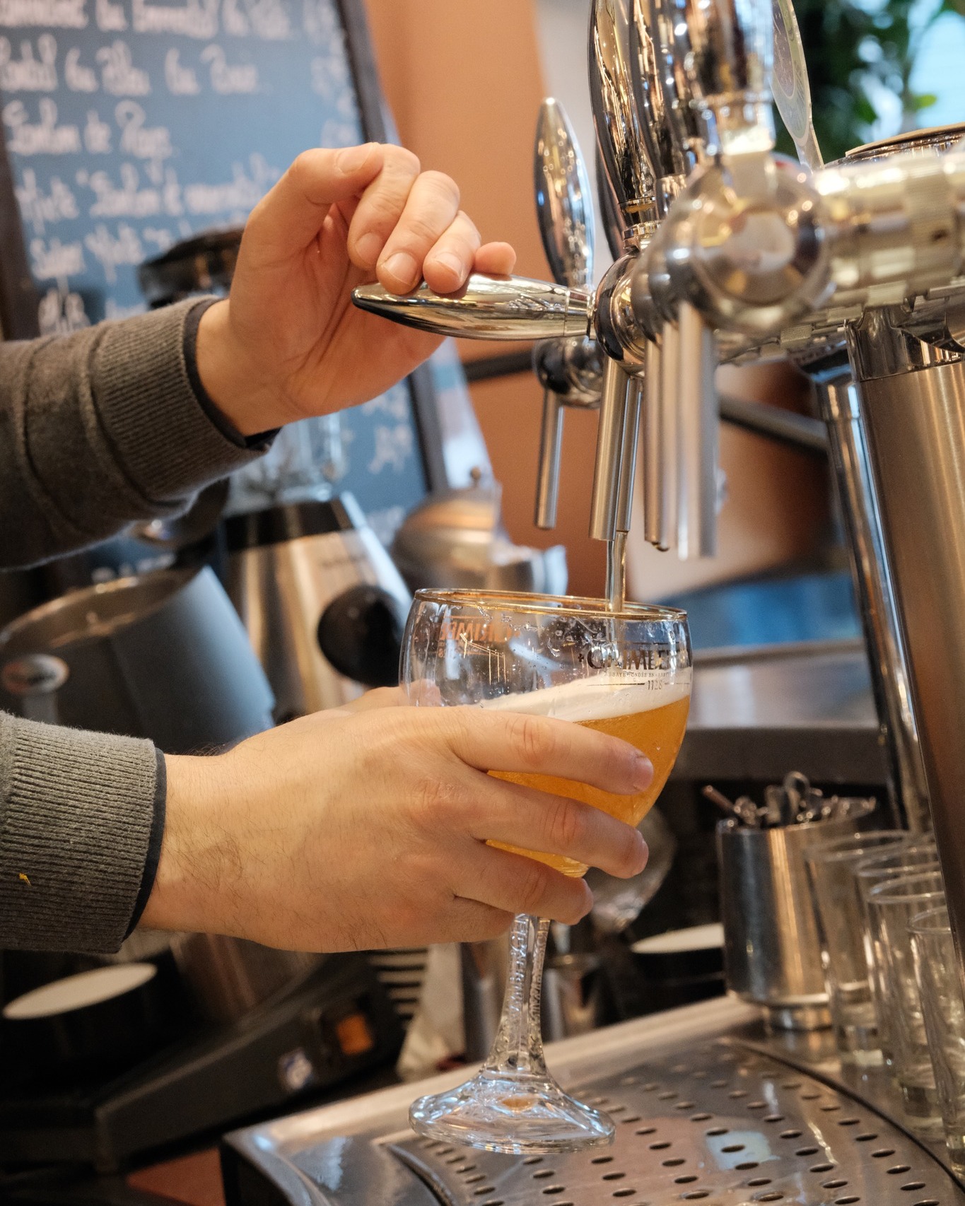 Verre de bière blonde à la pression avec robinet de bar en arrière-plan