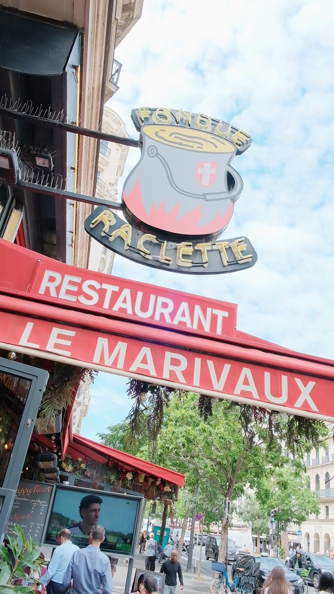 Façade du restaurant Le Marivaux avec enseigne vintage et terrasse parisienne