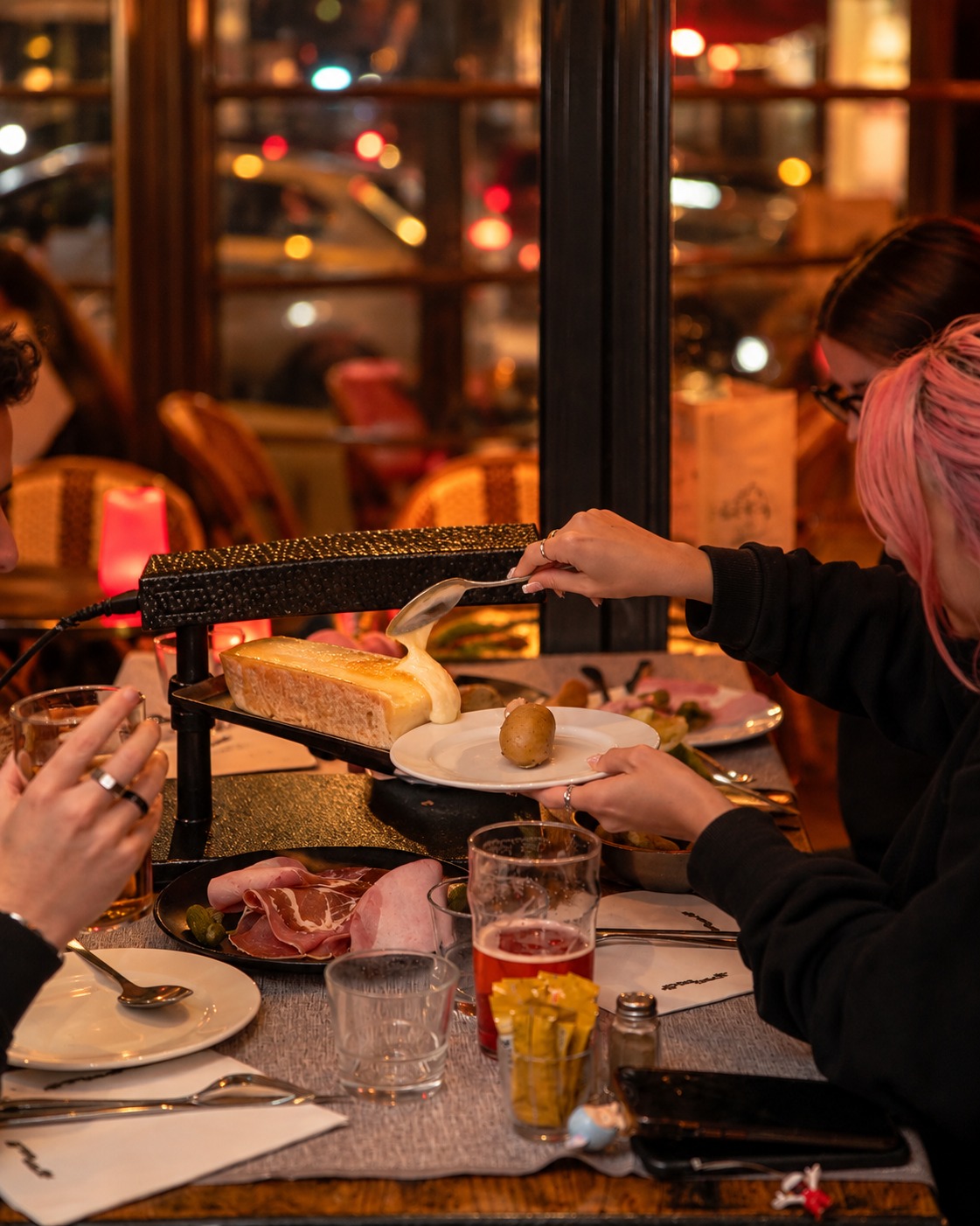 Raclette coulante et charcuterie servies à table au restaurant Le Marivaux Paris
