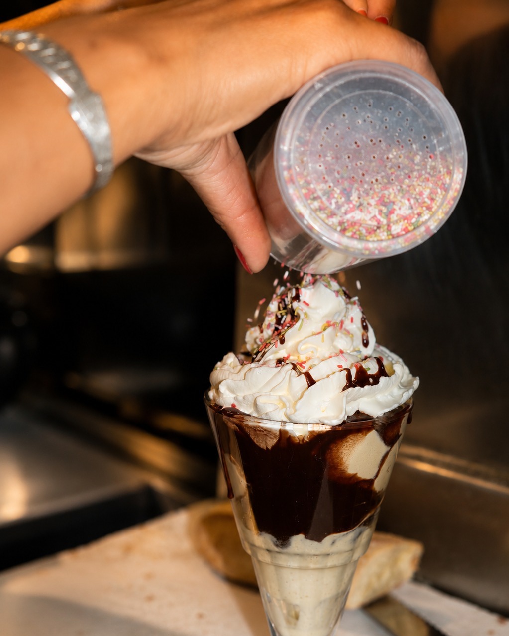 Coupe glacée au chocolat avec chantilly et perles sucrées colorées