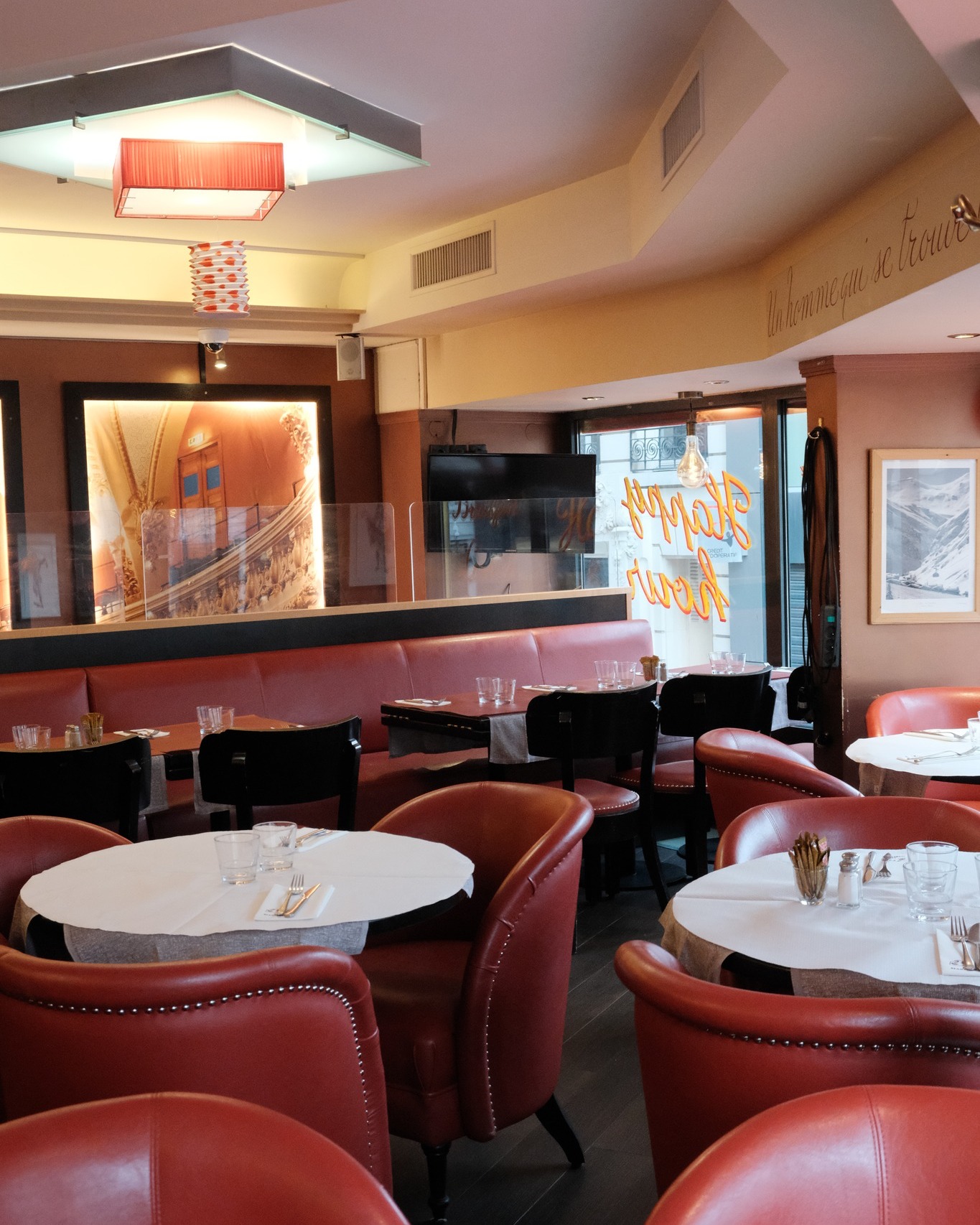 Salle de restaurant Marivaux avec fauteuils rouges et tables blanches rondes