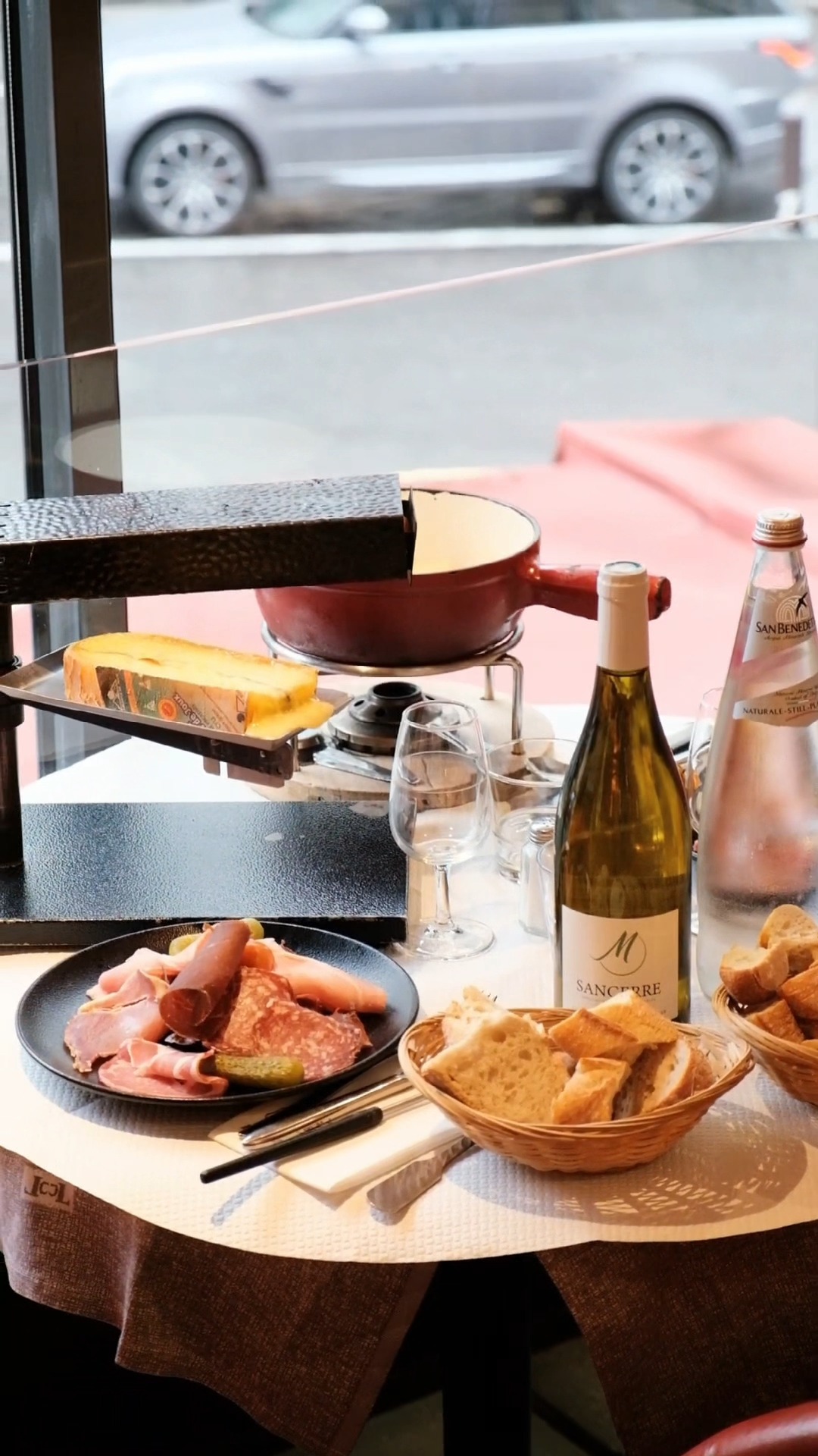 Table élégante avec charcuterie, fromage, pain et vin blanc au restaurant Le Marivaux