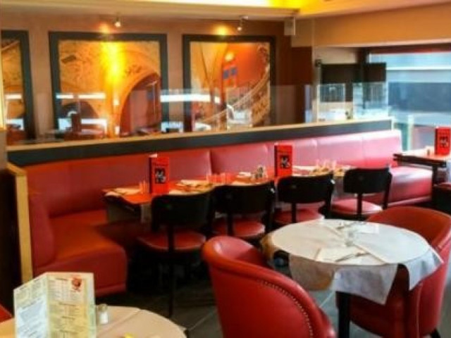 Salle de restaurant moderne avec banquettes rouges et décoration dorée