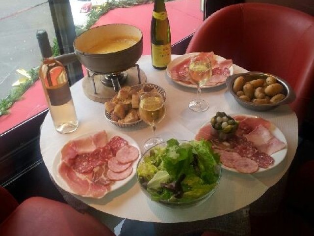 Table de dégustation avec charcuterie, fromage fondu et accompagnements en terrasse