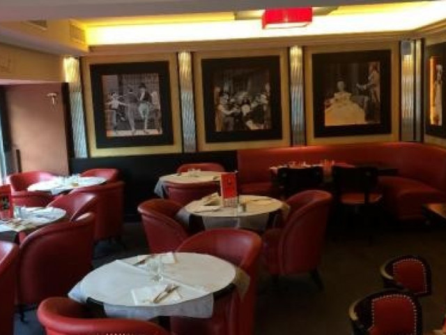 Salle de restaurant lounge avec fauteuils rouges et décoration artistique
