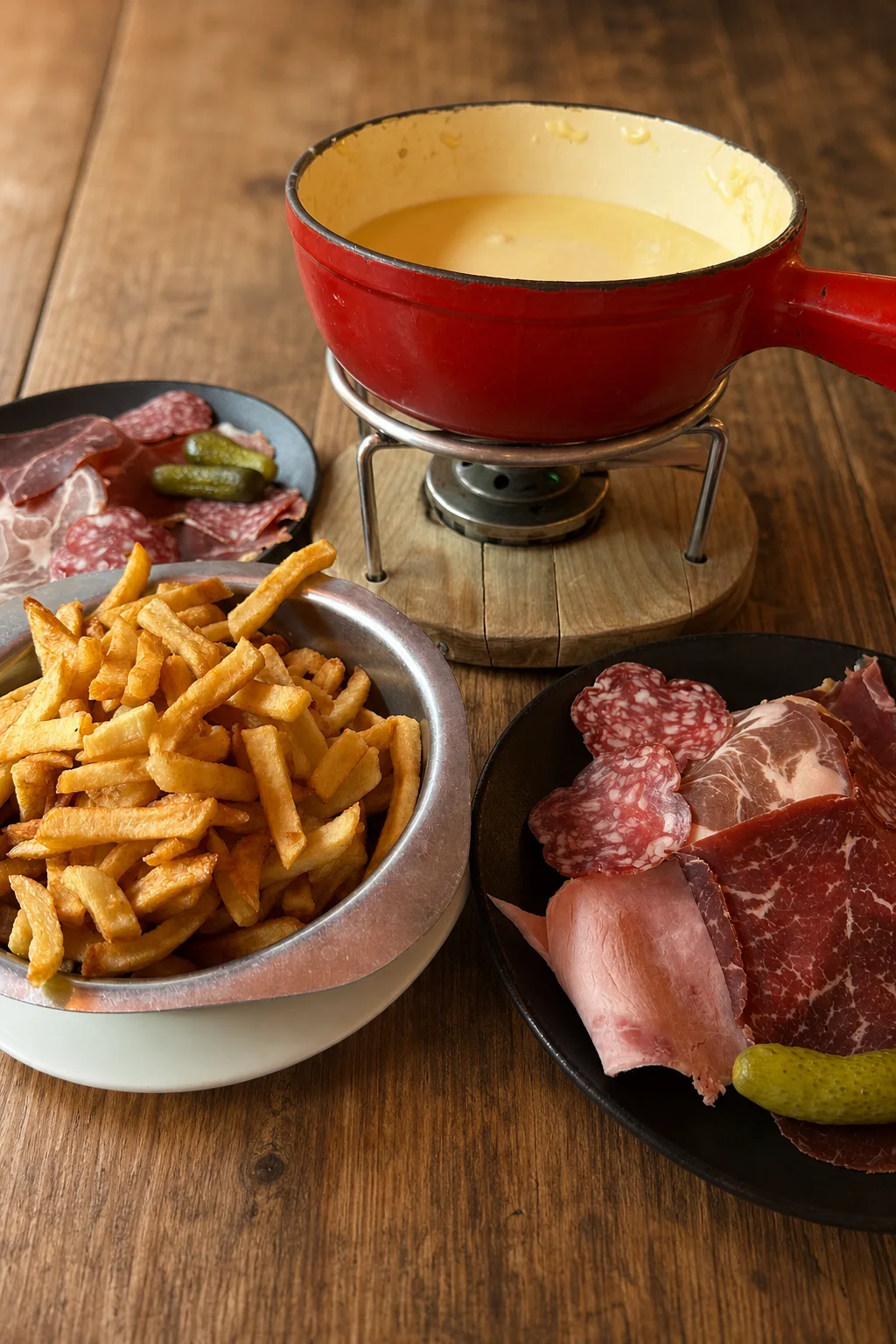 Fondue savoyarde avec charcuterie, frites et cornichons